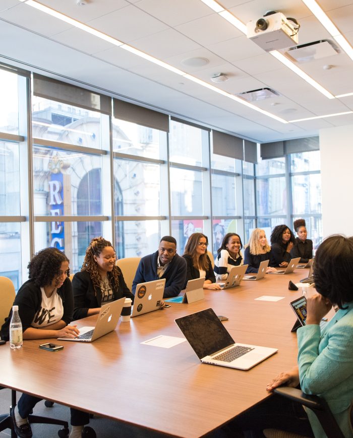 Sala de reunião com várias pessoas sentadas conversando.